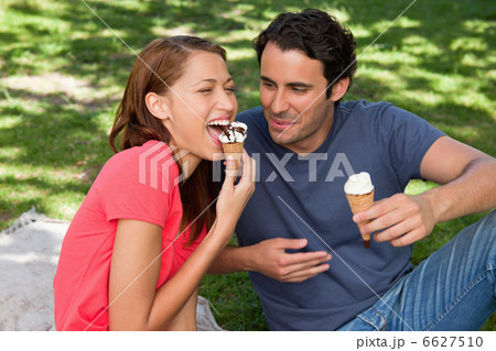 Woman eating ice cream while sitting with her friend Woman eating ice cream while sitting with her friend 6627510