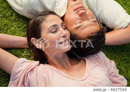 Man and a woman lying head to shoulder with their arm behind the Man and a woman lying head to shoulder with their arm behind the 6627569