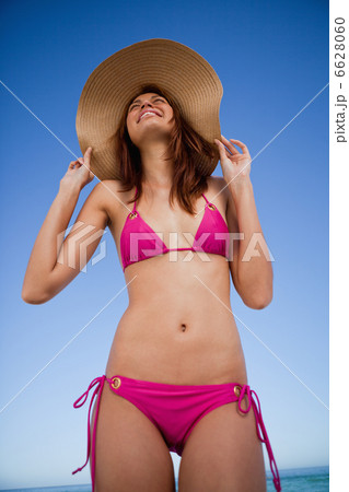 Low-angle view of a smiling teenager wearing a pink swimsuit 6628060