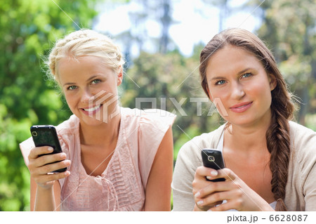 Friends with their cellphones in the park 6628087