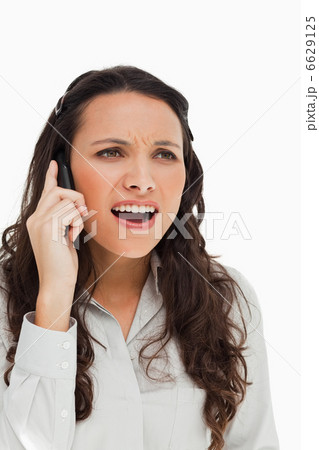 Portrait of a brunette grimacing while phoning Portrait of a brunette grimacing while phoning 6629125