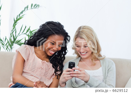 A woman is showing her friend her mobile phone A woman is showing her friend her mobile phone 6629512