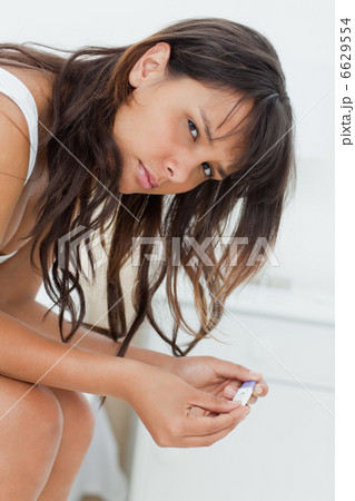 Unsmiling young woman waiting for a pregnancy test result 6629554