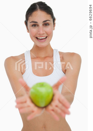 Close-up a brunette showing a green apple Close-up a brunette showing a green apple 6629694