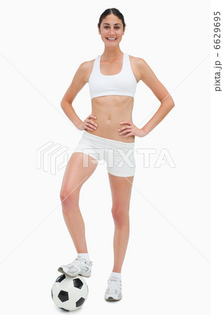 Slim young woman smiling in white clothes holding a soccer ball Slim young woman smiling in white clothes holding a soccer ball 6629695