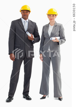 Two serious business people wearing hard hats 6630150