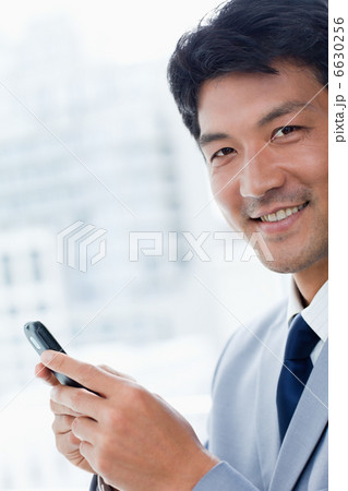 Portrait of a office worker using his mobile phone 6630256