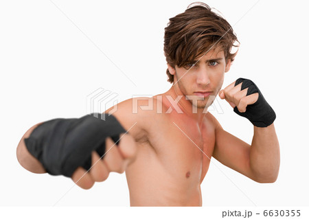 Martial arts fighter attacking with his fist Martial arts fighter attacking with his fist 6630355
