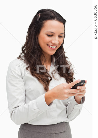 Brunette smiling while looking her text message 6630356