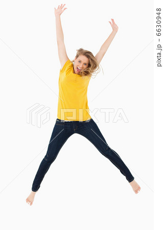 Young blonde woman in yellow shirt jumping Young blonde woman in yellow shirt jumping 6630948