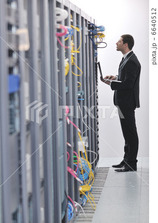 businessman with laptop in network server room businessman with laptop in network server room 6640512