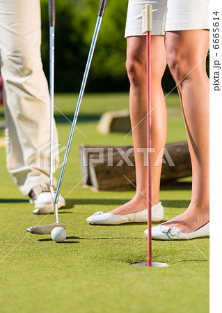 People playing miniature golf outdoors 6665614