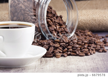 cup full of coffee and glass pot with beans on sack 6679578