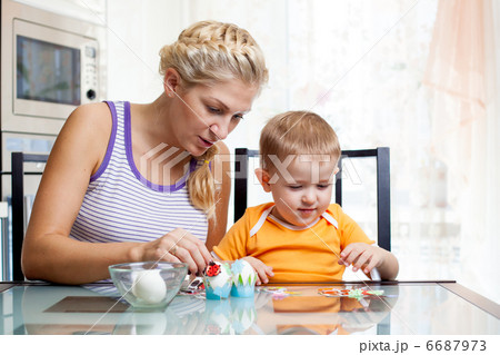 mother with son decorate easter eggs 6687973