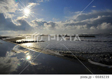 水面に写る冬の太陽の写真素材