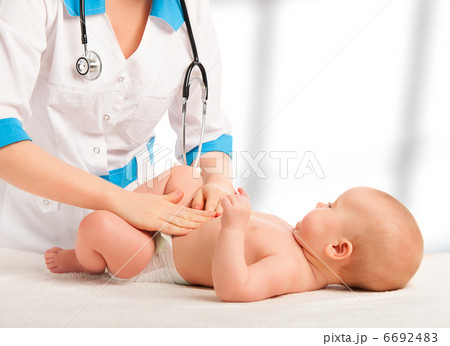 Doctor examines, massaging baby tummy 6692483