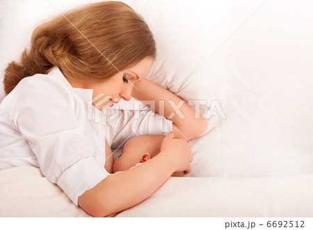 mother feeding her baby in the bed. sleeping together 6692512