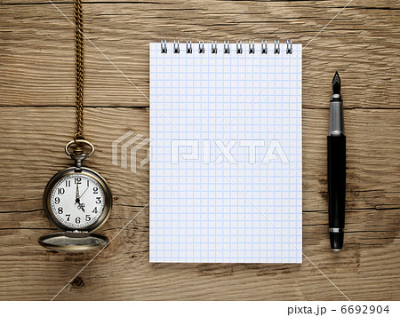 Pocket watch, fountain pen and note book on old wooden background 6692904