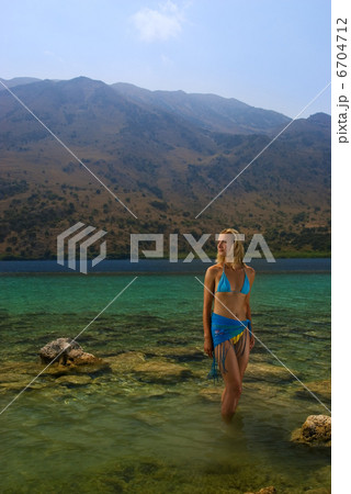 Beautiful blond girl standing in crystal clear water 6704712