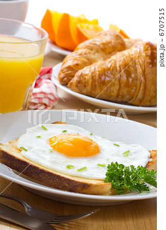 breakfast with fried egg, juice and croissant 6707515
