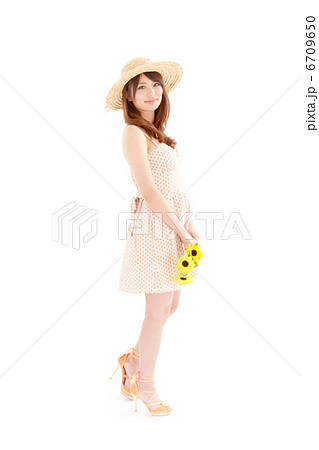 麦わら帽子に爽やかな真夏のワンピースが似合うラブリーな女の子の写真素材