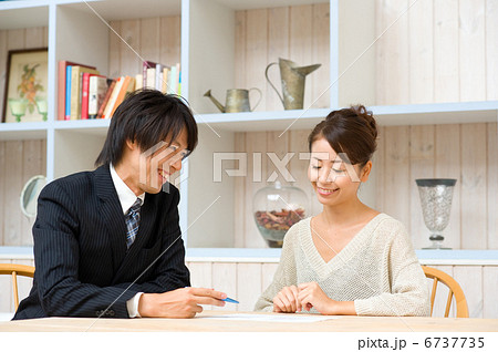 訪問販売で説明する営業マン 6737735