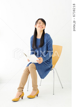 椅子に座って読書をする女の子の写真素材