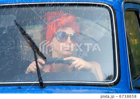 Vintage girl in car under rain Vintage girl in car under rain 6738658