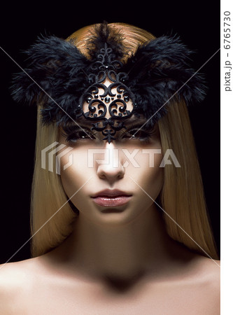 Beautiful Genuine Woman in Styled Black Mask with Feathers. Aristocratic Face 6765730