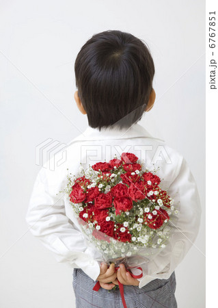 後ろ手に花束を持つ子供の写真素材