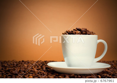 White cup filled with coffee beans 6767961