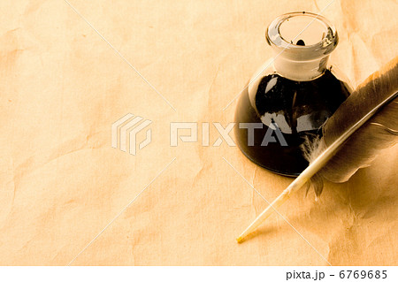Feather and ink bottle isolated on paper background Feather and ink bottle isolated on paper background 6769685