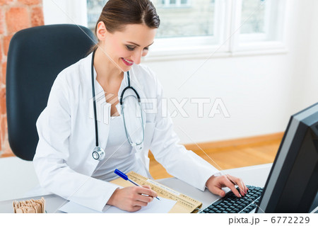 doctor at desk in clinic writing a file or dossier doctor at desk in clinic writing a file or dossier 6772229