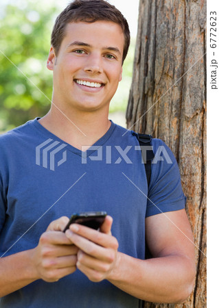 Portrait of a muscled student with a smartphone 6772623