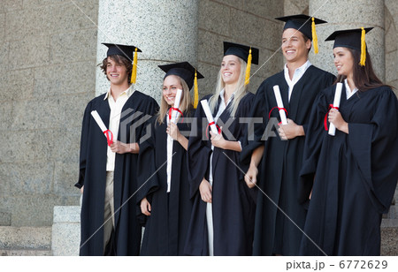 Smiling graduates posing while holding their diploma Smiling graduates posing while holding their diploma 6772629