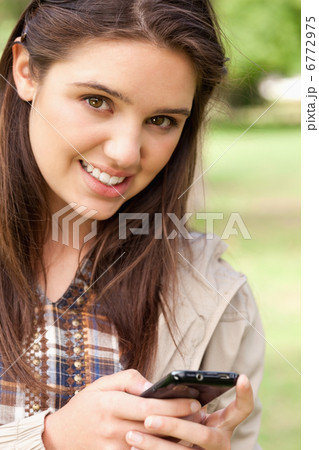 Portrait of a cute teenager using a smartphone 6772975