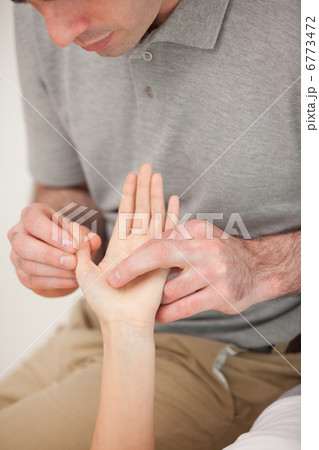 Man massaging the thumb of a woman 6773472