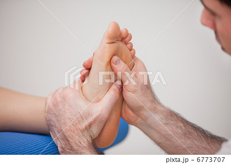 Podiatrist practicing reflexology on the foot of woman 6773707