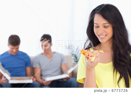 Woman smiling as she looks at the pizza slice with her friends b 6773726