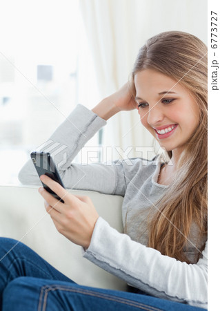 Smiling girl with her mobile phone as she checks her messages 6773727