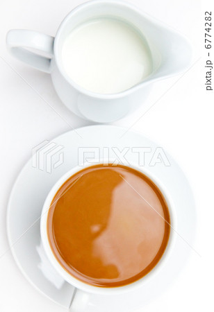 White cup of coffee next to a milk pot 6774282