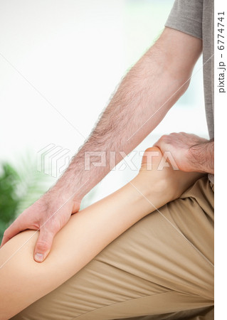 Physiotherapist massaging the leg of a woman Physiotherapist massaging the leg of a woman 6774741