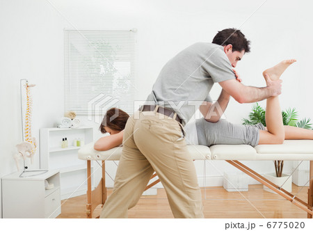 Brunette woman being stretched by a physiotherapist 6775020