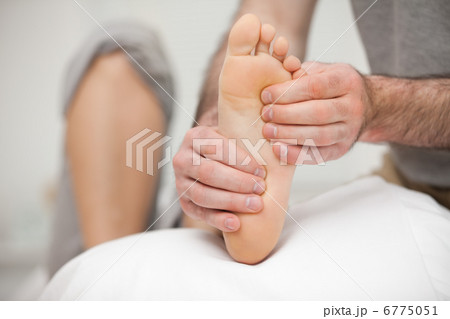 Chiropodist palpating the sole of the foot of a patient 6775051