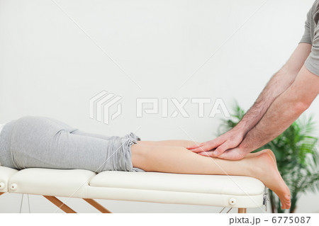 Close up of a masseur massaging the calves of a woman 6775087