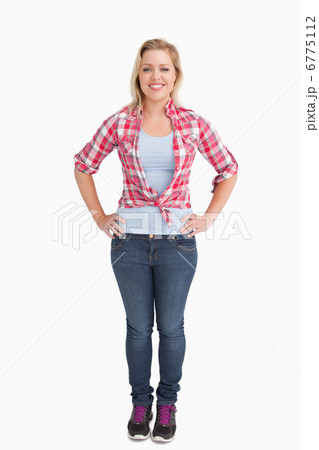 Happy young woman placing her hand on her hips 6775112