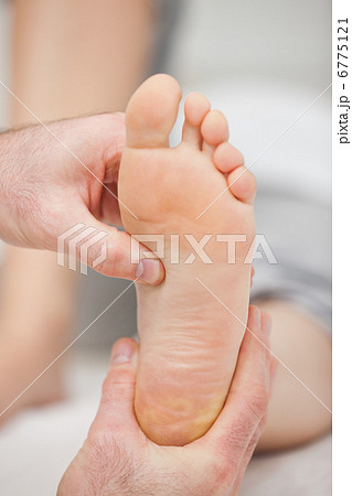 Doctor pressing the sole of a foot with his thumb 6775121