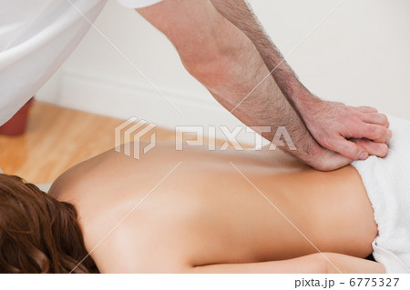 Therapist massaging the back of his patient while standing 6775327
