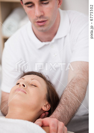 Physiotherapist manipulating the neck of his patient 6775502