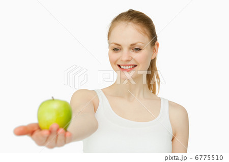 Cheerful woman presenting an apple Cheerful woman presenting an apple 6775510